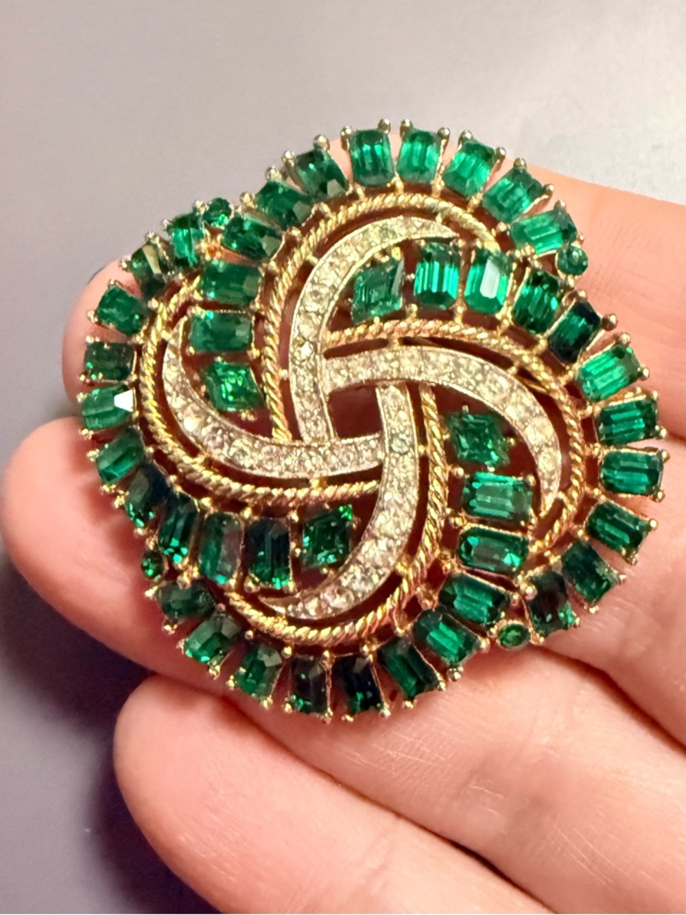 Signed Trifari Gold tone woven ribbon swirl brooch with emerald-cut stones